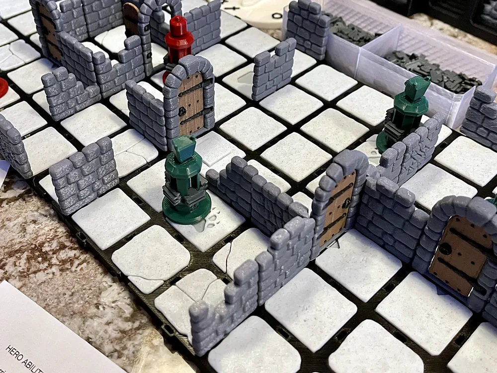 A Dungeon Dive playtest board with walls, doors and figurines, next to handwritten rule notes