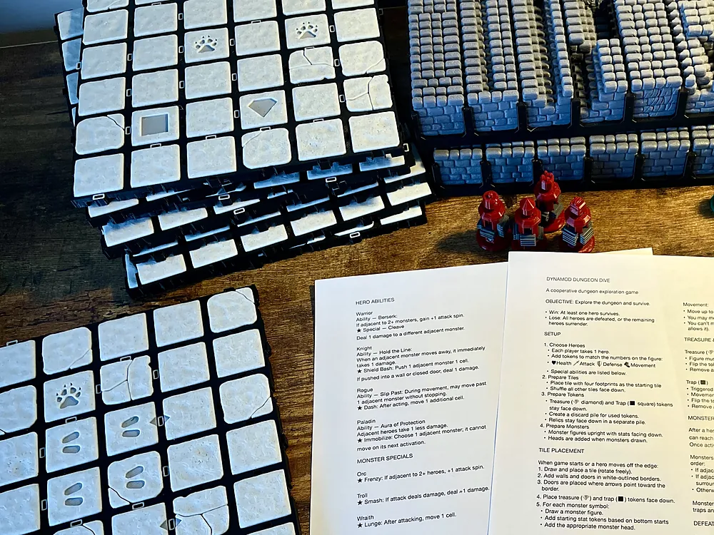 Dungeon Dive laid out at home: board tiles, hero and monster figurines, the spinner and printed rules on a wooden table